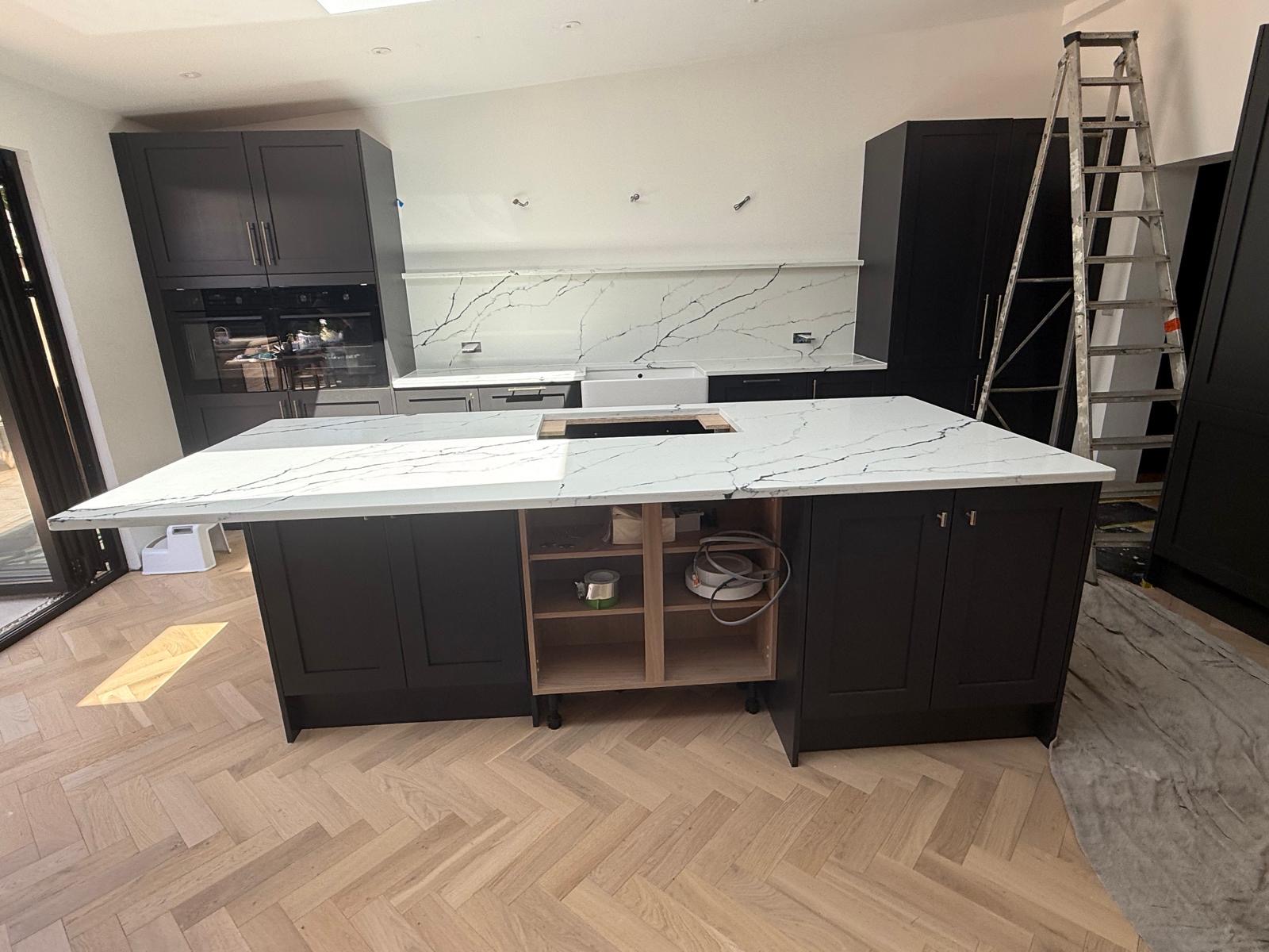 Calacatta quartz island and splashback in black shaker kitchen
